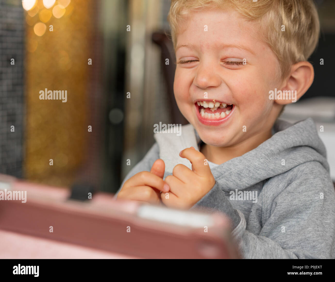 Bambino seduto nella sedia alta gioca e sorridente felicità al ristorante cinese.La luce naturale con uno sfondo bokeh bella,la foto in orizzontale. Foto Stock