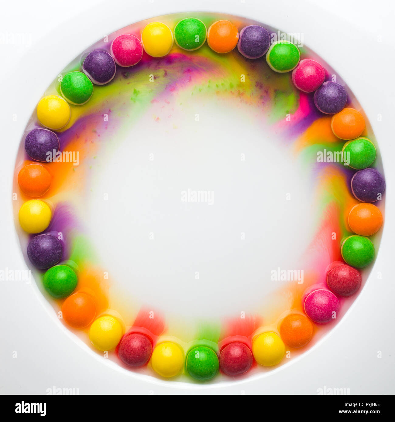 Cerchio di vetrate colorate caramelle su sfondo bianco. caramelle fusione in diverse righe, formando un arcobaleno Foto Stock