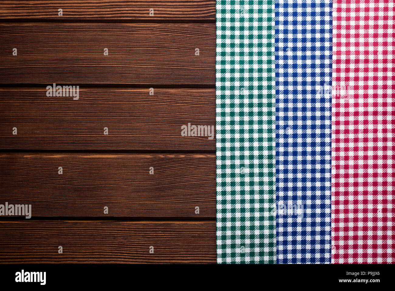 Tovagliolo in un rosso, verde, blu e bianco gabbia su una tavola di legno backgrou Foto Stock