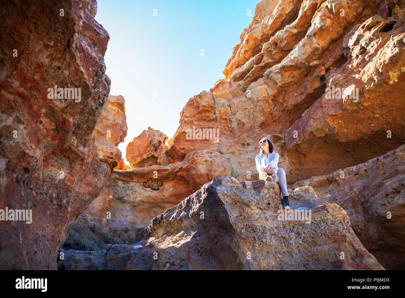 Traveler donna seduta sulla montagna nel canyon. Parco nazionale di Tenerife, Isole Canarie, Spagna Foto Stock