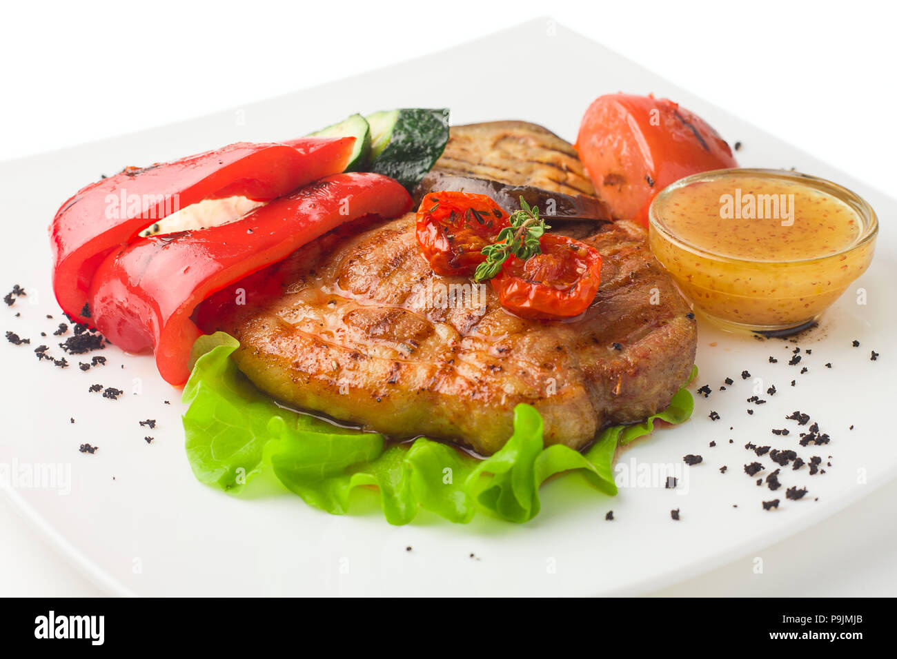 Succosa carne di maiale alla griglia con le verdure su uno sfondo bianco, isolat Foto Stock