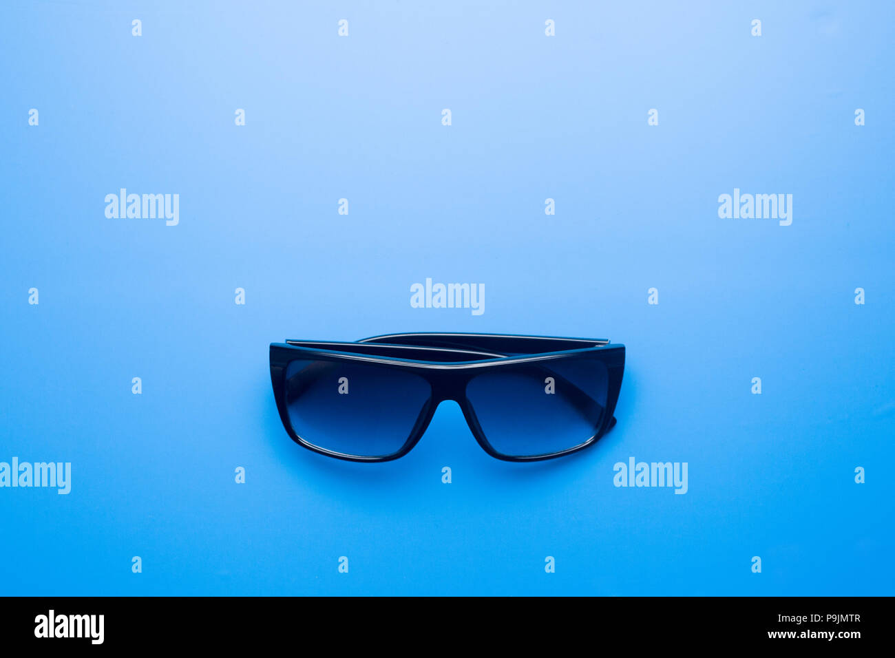 Occhiali da sole su un azzurro sfondo colorato, concetto di estate Foto Stock