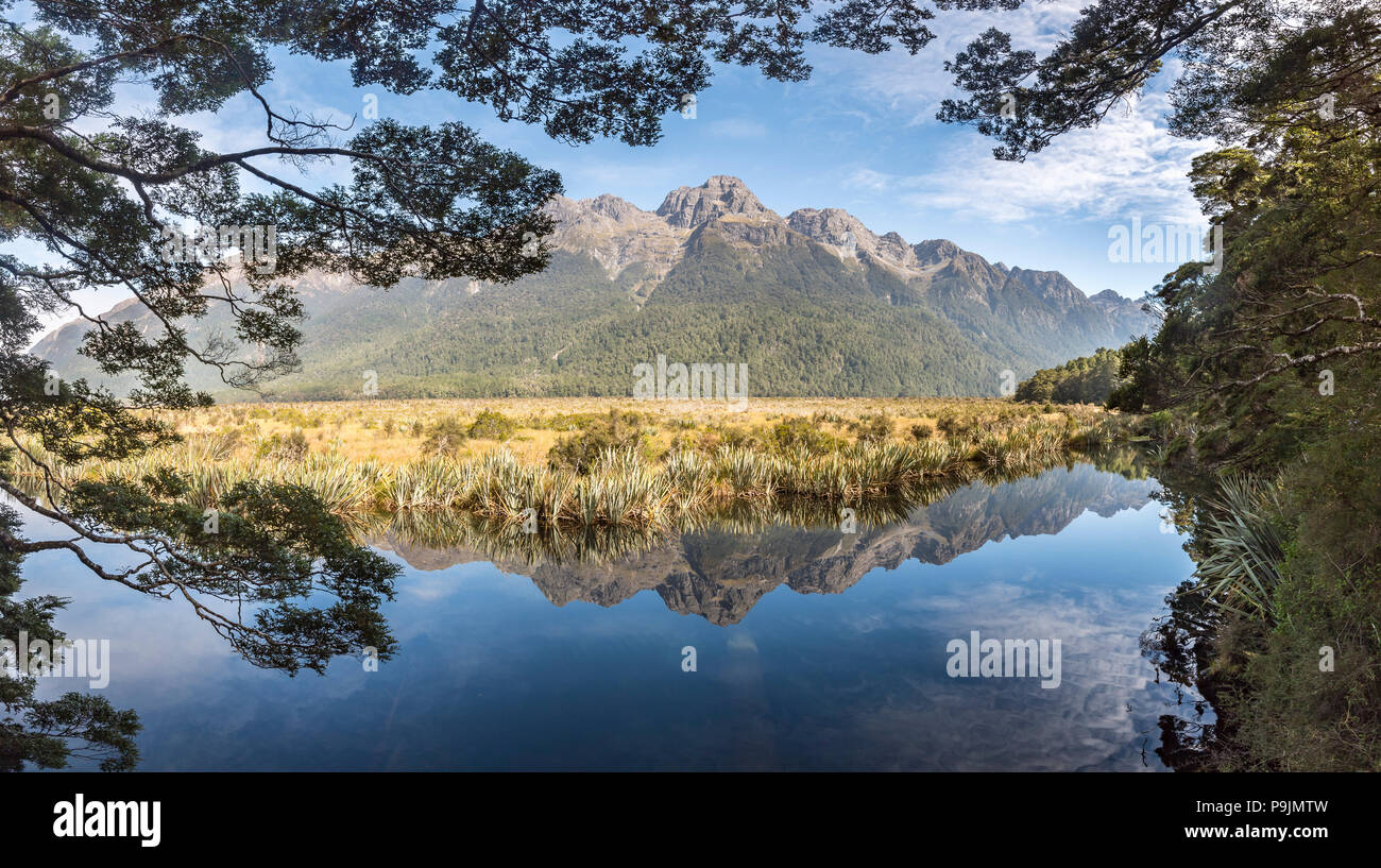 Mirror Lake con acqua riflessioni sulle montagne, il Parco Nazionale di Fiordland, Milford autostrada, Southland, Nuova Zelanda Foto Stock