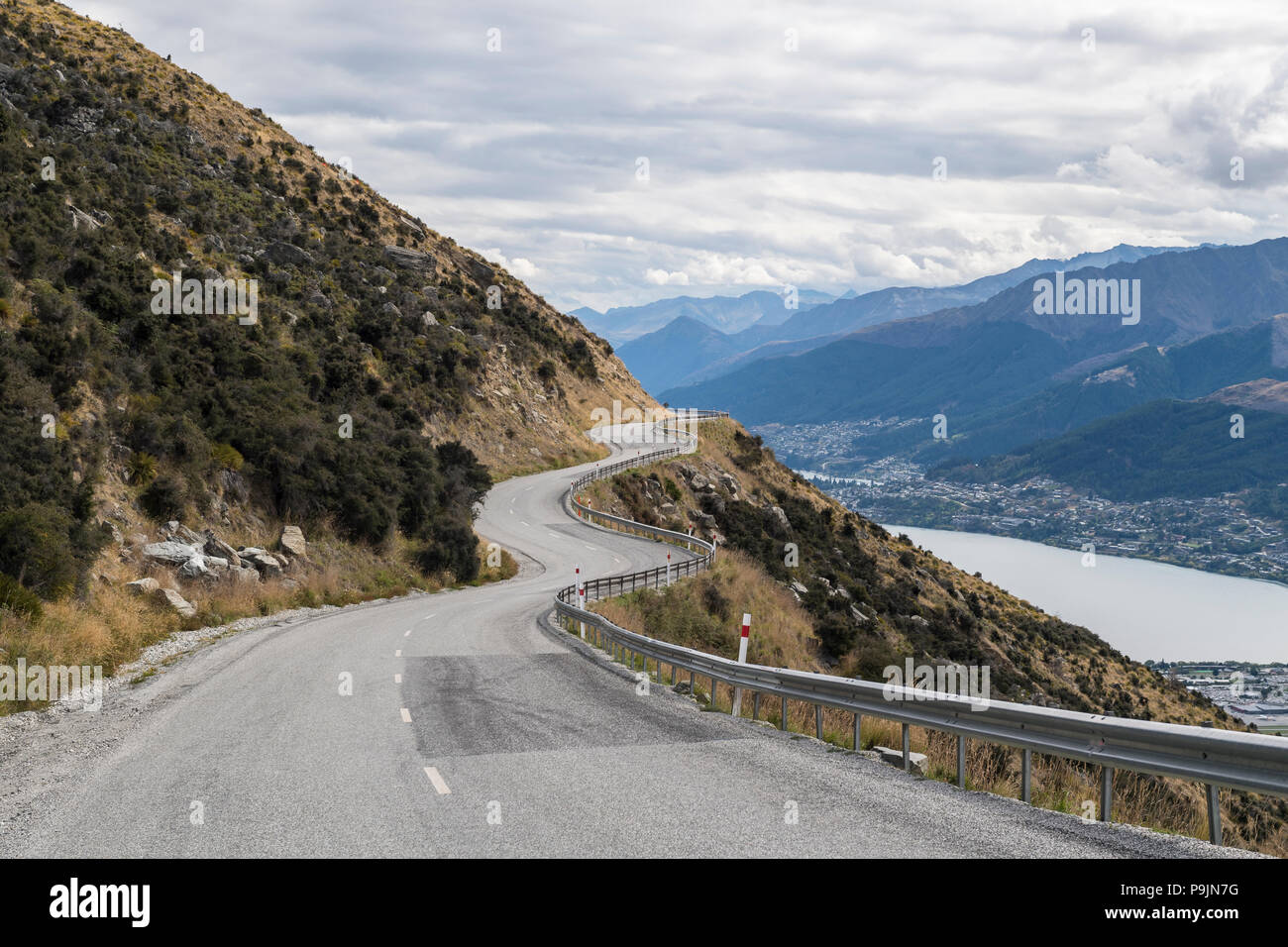 Curva road nella gamma della montagna il Remarkables, al di sotto di Queenstown e il lago Wakatipu, Otago, Isola del Sud, Nuova Zelanda Foto Stock