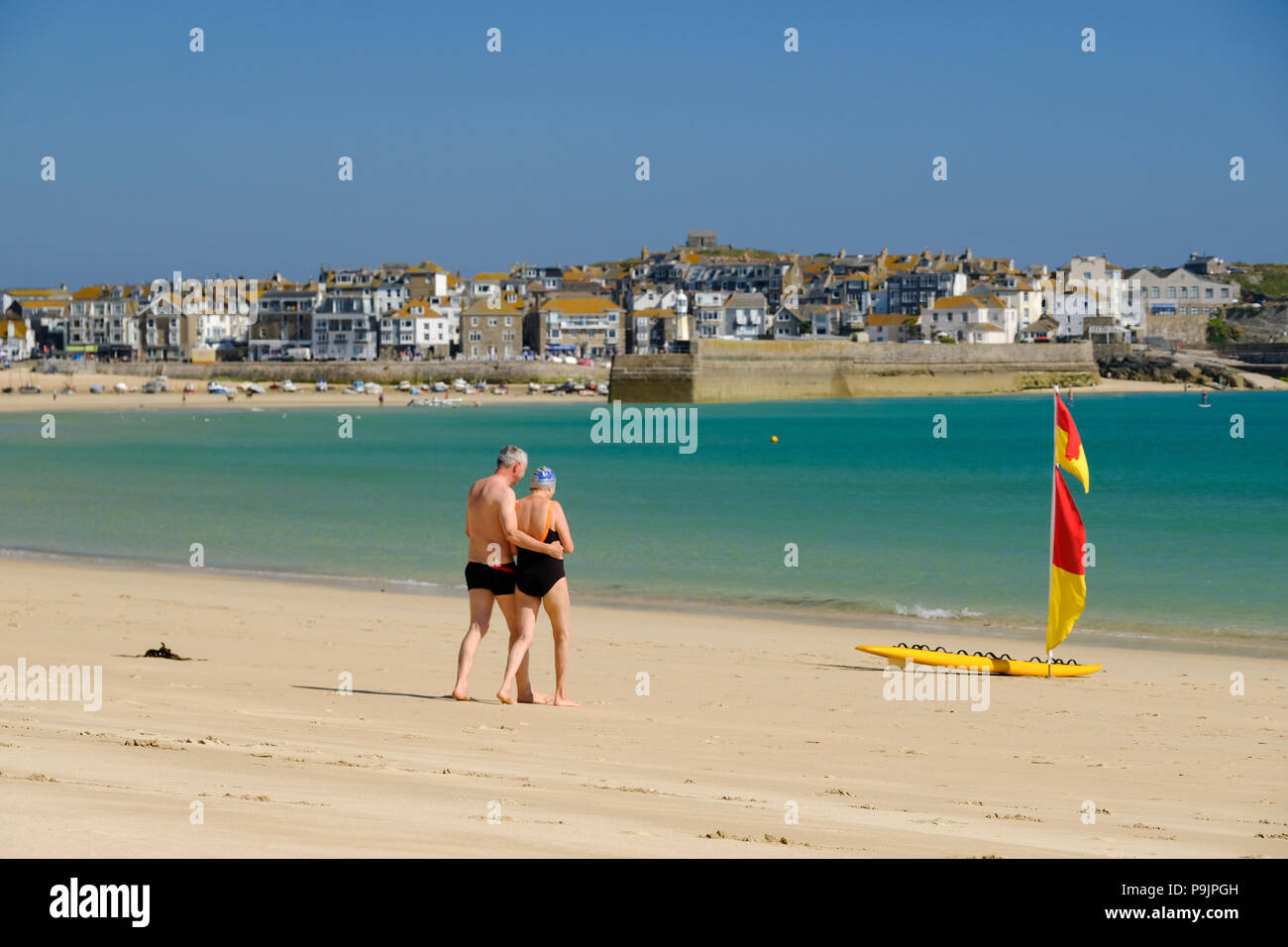 Giovane di età compresa tra circa 60 a camminare verso il mare sulla spiaggia di Porthminster a St Ives in Cornovaglia in estate. Foto Stock