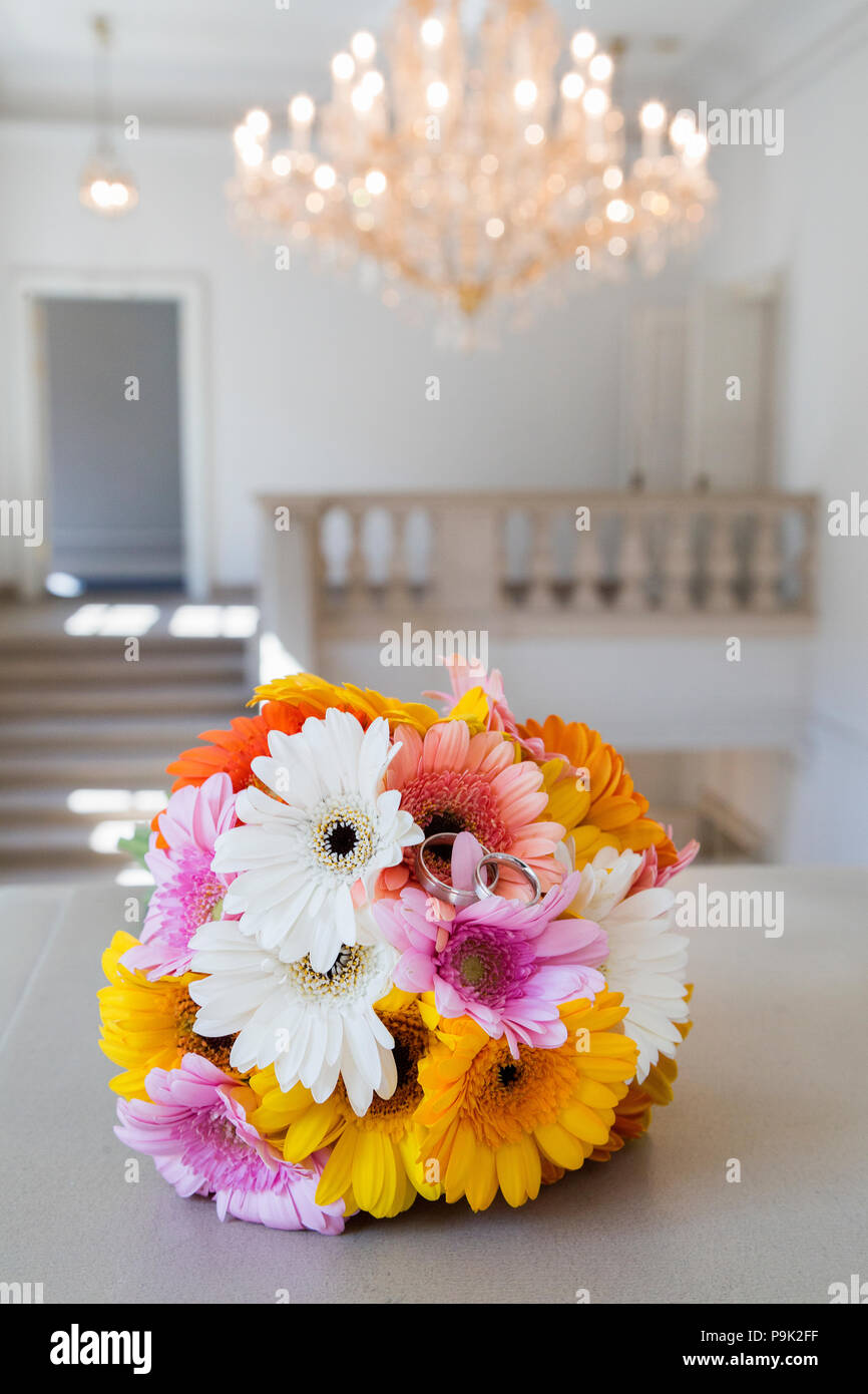 Bouquet di crisantemi e gli anelli giacente su marmo Foto Stock