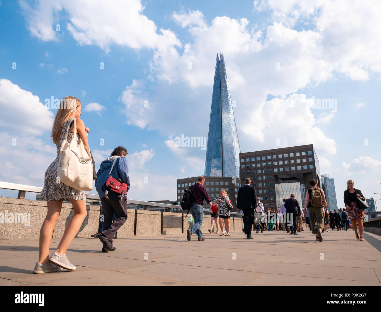Le persone che attraversano il ponte di Londra con la Shard in background, London, Regno Unito Foto Stock