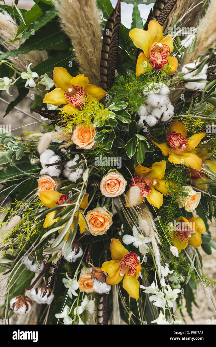 Wedding floreale con giallo orchidee, rose, essiccati fiori selvaggi sul cerimonia in stile Boho Foto Stock