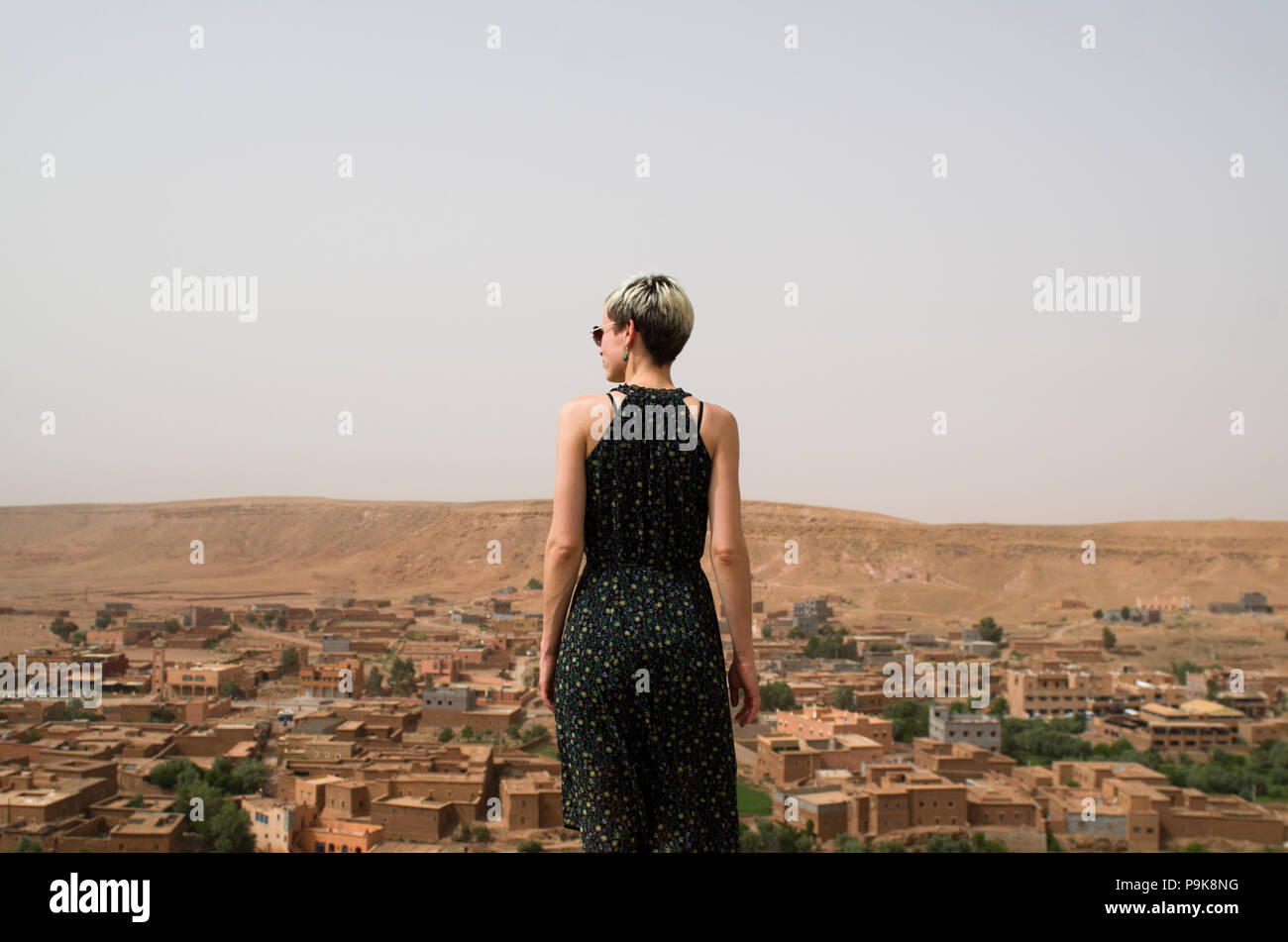 Donna in piedi al di sopra di un villaggio, Marocco Foto Stock