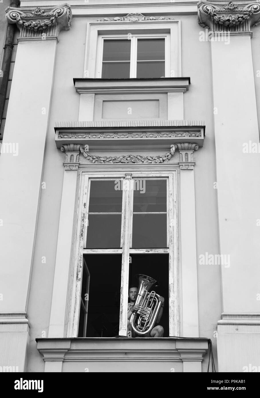 Musicista esegue la riproduzione da appartamento windows a Cracovia Polonia Foto Stock