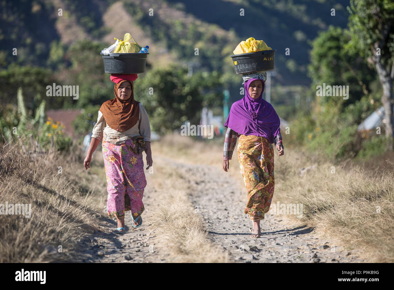 SEMBALUN LAWANG, Indonesia - 26 agosto 2017: le donne non identificato a piedi una strada non sviluppata in Sembalun Lawang. Foto Stock