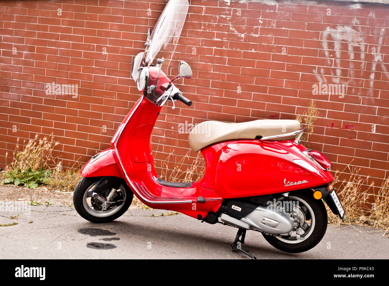 Red scooter Vespa Primavera parcheggiato sulla strada Foto Stock