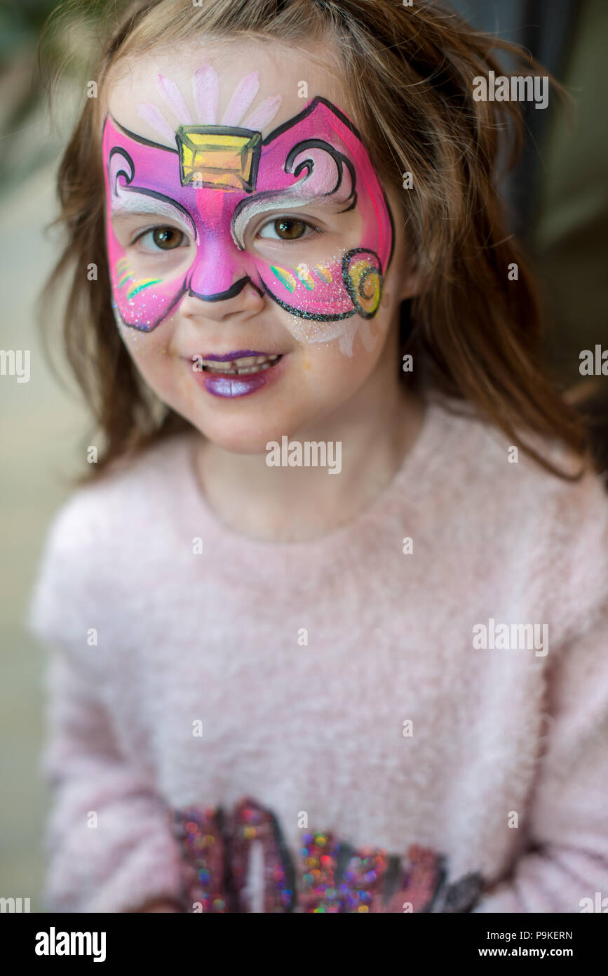 Entusiasta carina ragazza giovane con la pittura del viso come una farfalla Foto Stock