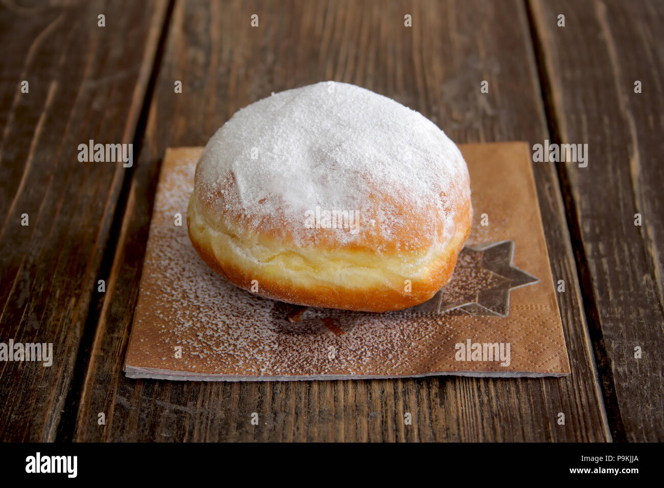 Jelly donut sul tovagliolo su sfondo di legno Foto Stock