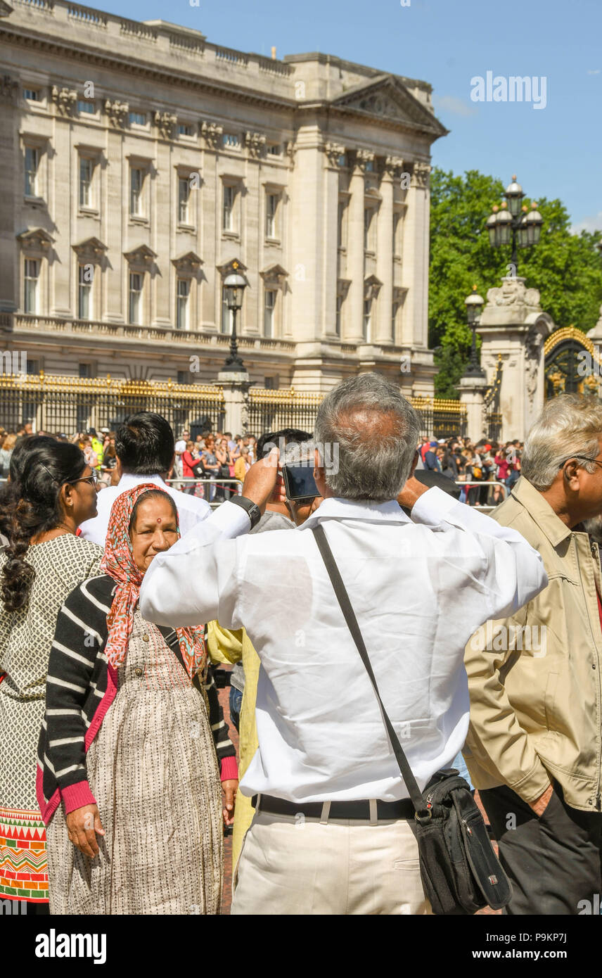 I turisti di scattare una foto dei membri della famiglia al di fuori Buckingham Place Foto Stock