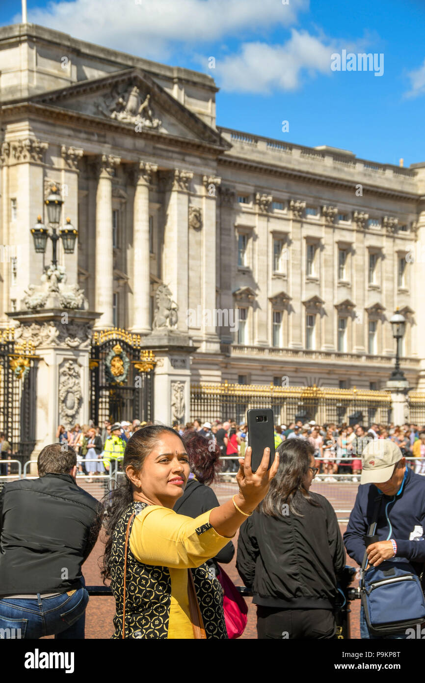 Turistica prendendo un immagine selfie fuori Buckingham Place Foto Stock