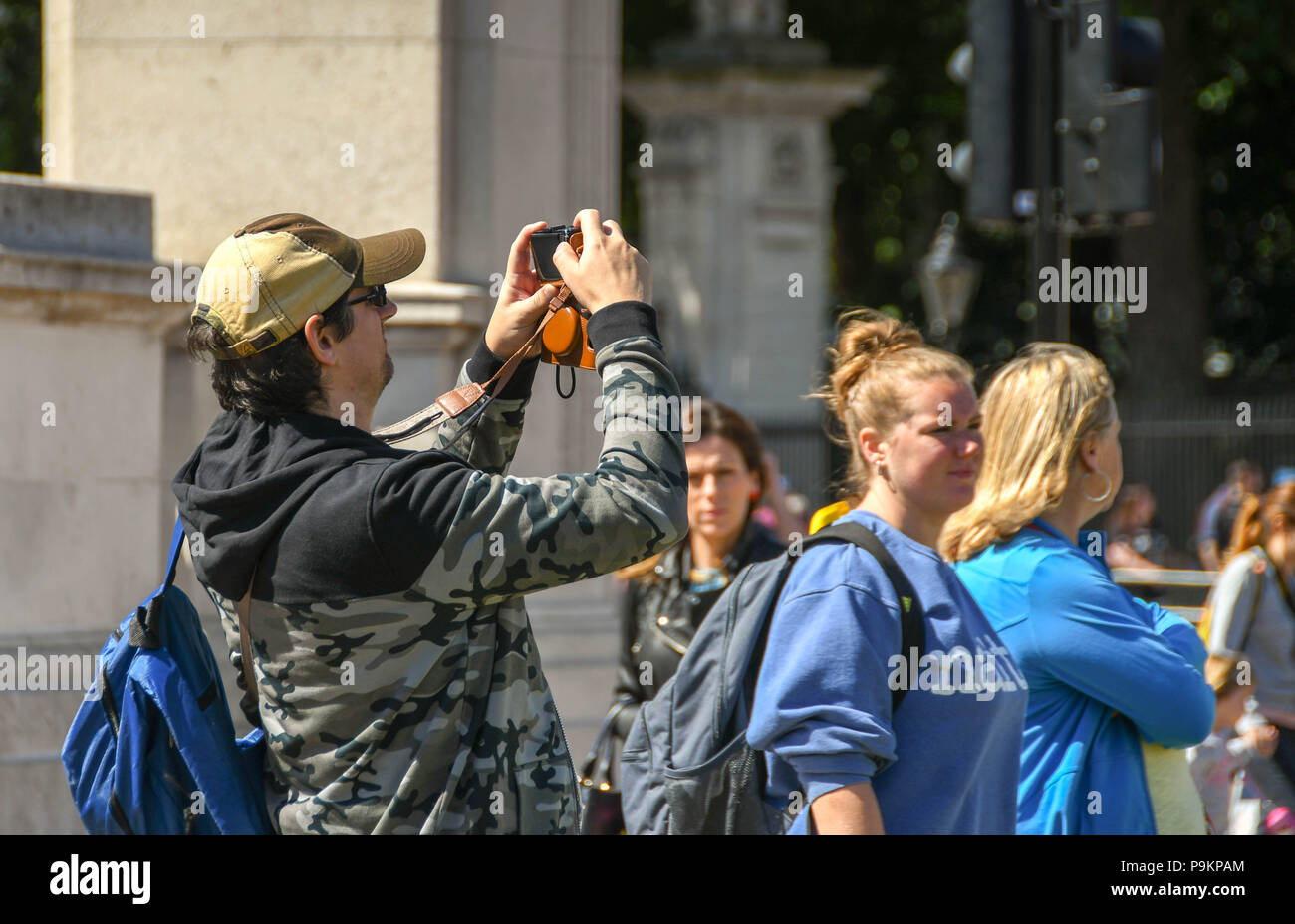 I turisti di scattare una foto al di fuori Buckingham Place con altri turisti in background Foto Stock