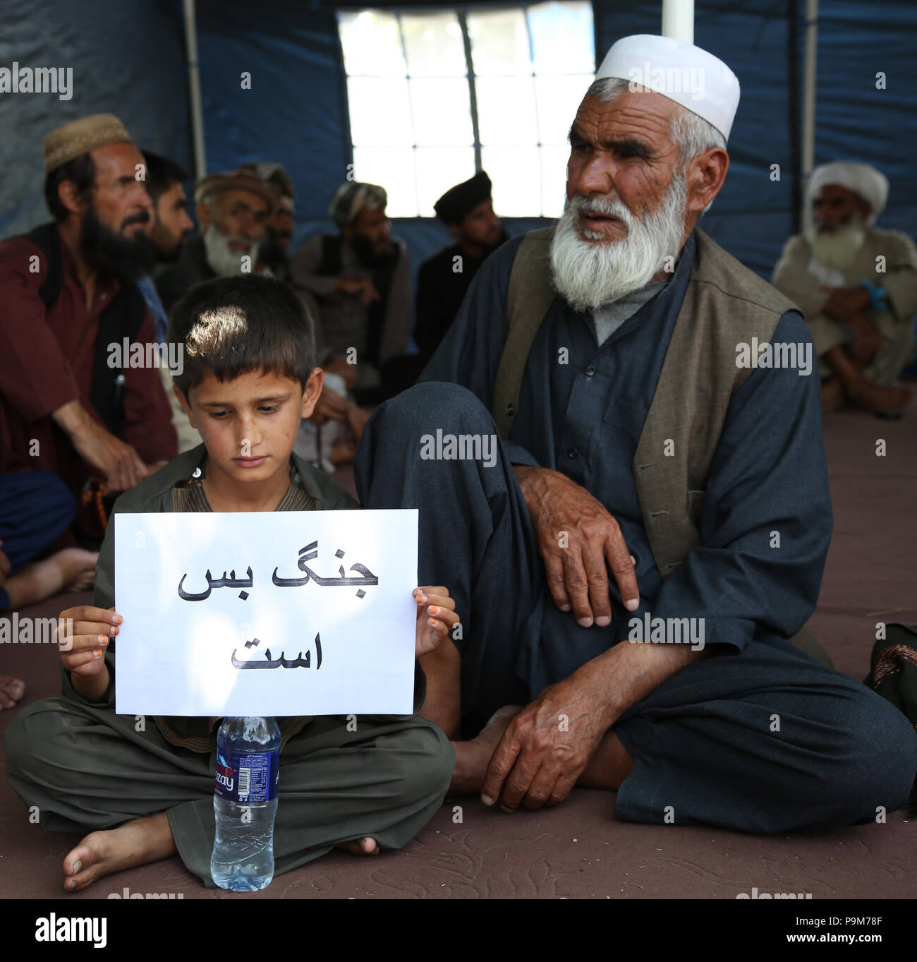 A Kabul, Afghanistan. 19 Luglio, 2018. Un ragazzo tiene un cartello che recita "la guerra è abbastanza' durante una manifestazione chiamata per la pace a Kabul, Afghanistan, luglio 19, 2018. La NATO-led supporto risoluto (RS) Missione confutato media i rapporti che gli Stati Uniti erano pronti a partecipare a negoziati diretti con i Talebani outfit, secondo una dichiarazione del RS per affari pubblici qui ricevuto martedì. Credito: Rahmat Alizadah/Xinhua/Alamy Live News Foto Stock