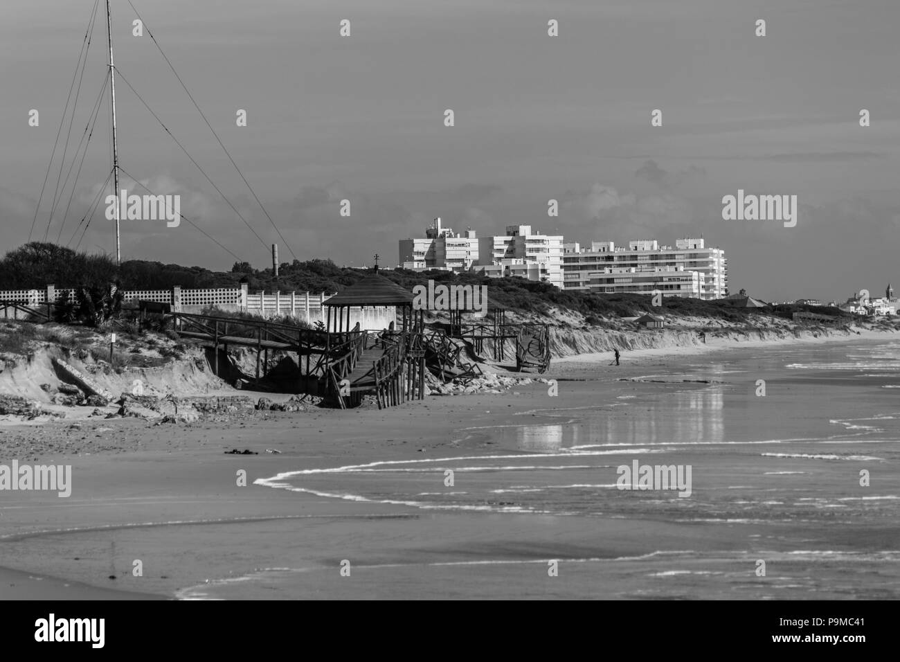 Spagnolo spiaggia con residenti a piedi e la città sullo sfondo Foto Stock