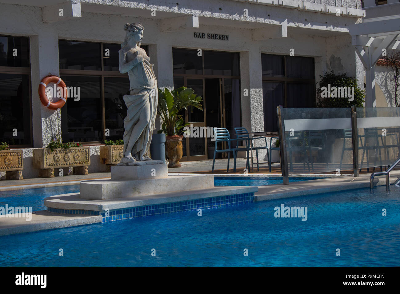 Statua in piedi alla testa di una piscina del resort Foto Stock