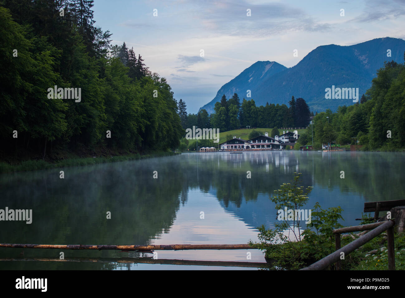 La nebbia e il lago balneare delle Alpi mountain range Foto Stock