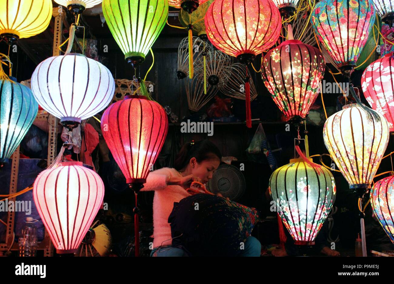 Donna che fa il tessuto lampade in Hoian Foto Stock