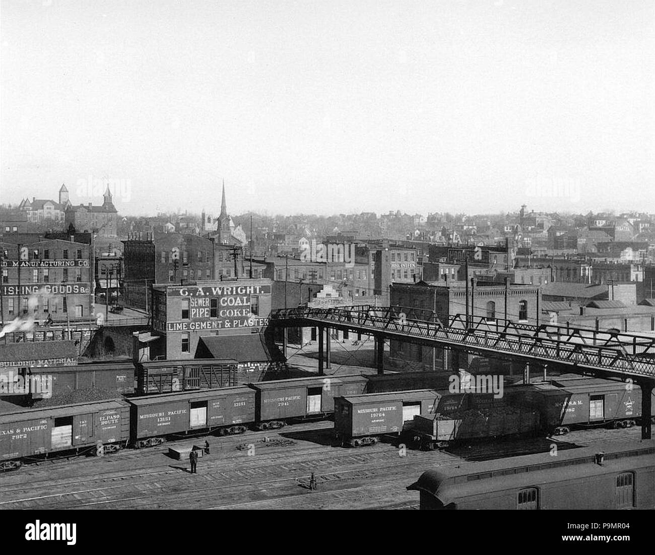 . Inglese: fotografia mostra una vista del cantiere ferroviario sotto la parte inferiore della sesta strada viadotto sul lato est di Atchison, Kansas. Sono visibili anche le vetture del trasporto merci (compresi Missouri Pacific, Texas & Pacific, Kansas City, Fort Scott, & Memphis vetture ferroviarie) e business, la chiesa e la residenza di edifici di Atchison orientale. circa 1880-1900 163 Atchison, Kansas (circa 1880-1900) Foto Stock