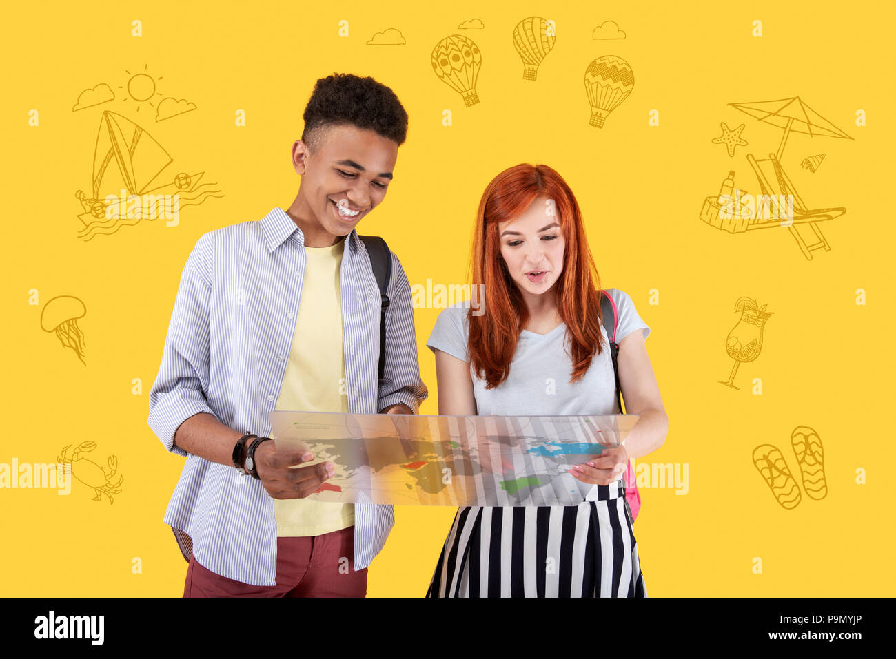 Gli adolescenti positivo sorridente e pianificare il loro viaggio con una mappa Foto Stock