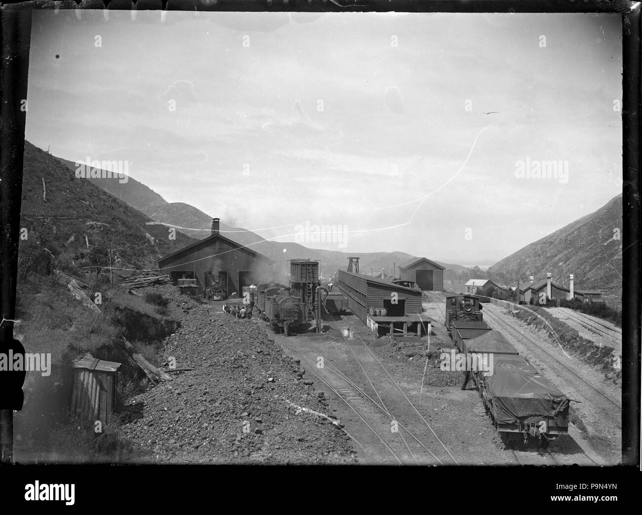 324 vista dei cantieri ferroviari, motore capannoni, e ferroviaria case, probabilmente a Cross Creek sulla linea Wairarapa ATLIB 274522 Foto Stock