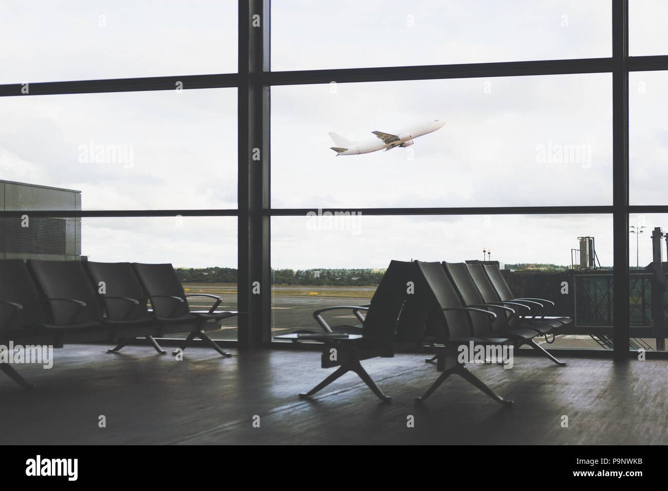 Il concetto di viaggio - vuoto interno dell'aeroporto lounge sullo sfondo del volo di aeromobili (effetto vintage) Foto Stock