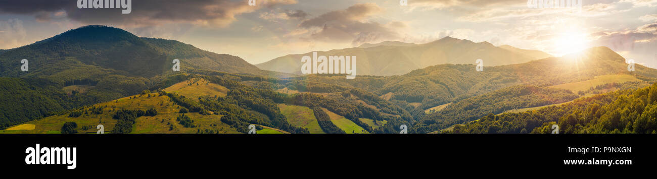 Panorama di montagna bella ridge al tramonto nella luce della sera. perfetto paesaggio di campagna. campo rurale sulla più vicina colline boscose. Mighty Borz Foto Stock