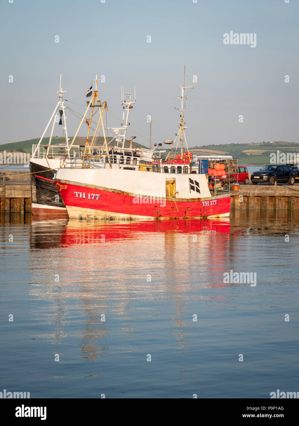 In rosso di un peschereccio da traino o di pesca in barca ormeggiata al Porto a Padstow Cornwall Regno Unito al caldo sole della sera Foto Stock