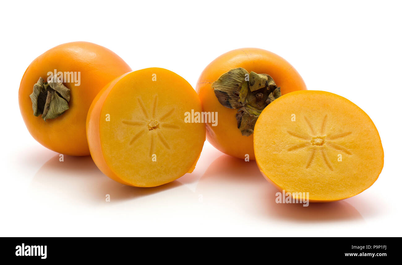 Persimmon Kaki isolati su sfondo bianco due interi uno tagliati a metà Foto Stock