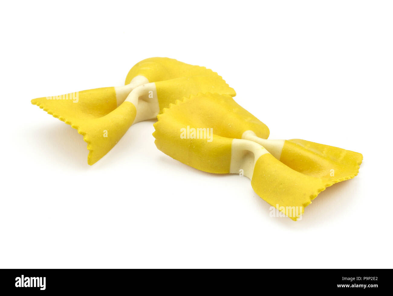 Farfalle di pasta con curcuma isolati su sfondo bianco due materie classico e tradizionale giallo italiano Foto Stock