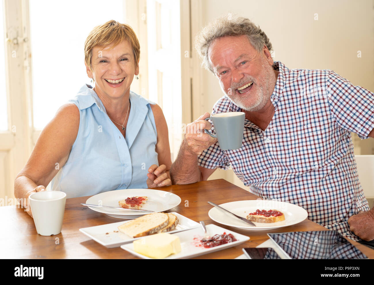 Ritratto di un attraente coppia coppia in pensione con prima colazione insieme a casa godendo la pensione di stile di vita dei pensionati in amore famiglia felice mom Foto Stock