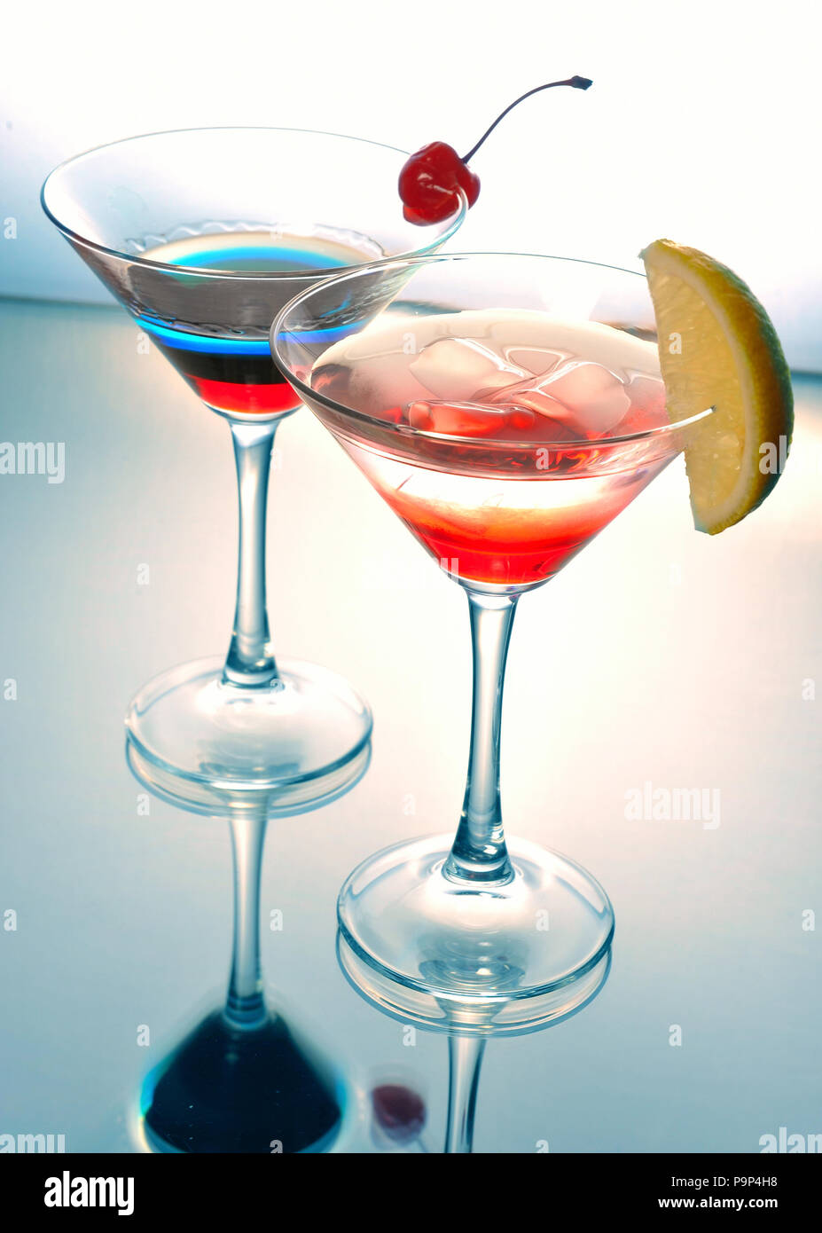 Due cocktail Martini con una ciliegia su uno sfondo bianco Foto Stock