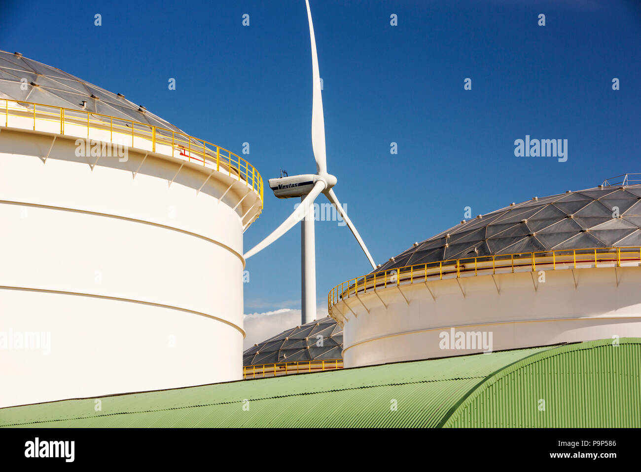 Il cambiamento climatico il cielo e l'inferno, un terminale petrolifero di Amsterdam, Paesi Bassi, con turbine eoliche che generano energia rinnovabile Foto Stock