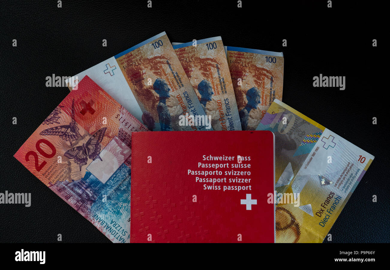 Passaporto Svizzero e denaro close up su sfondo nero la cittadinanza svizzera e moneta Foto Stock