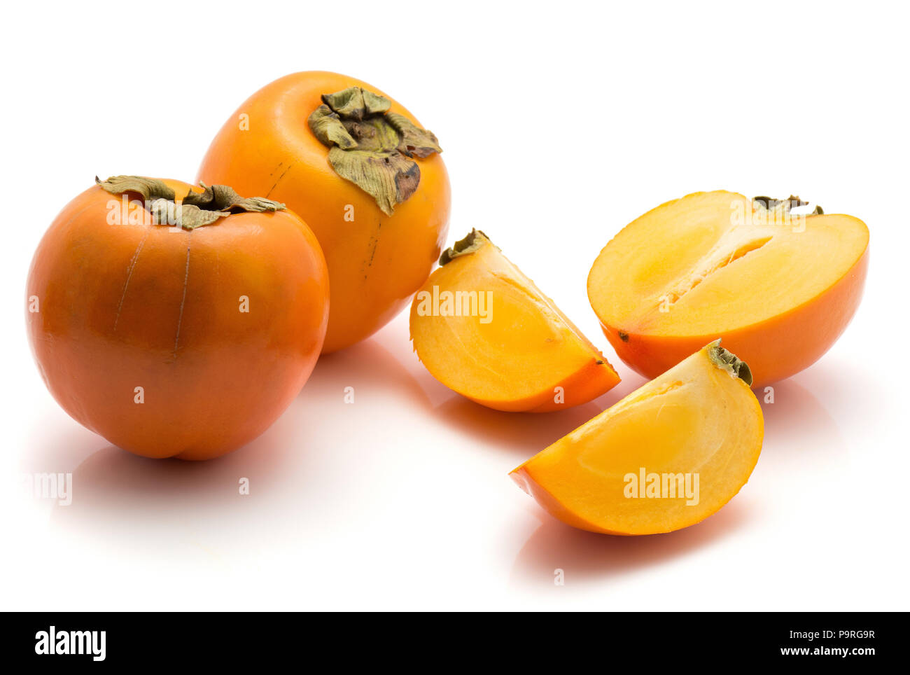 Affettato Kaki persimmon isolati su sfondo bianco due interi metà due fette Foto Stock