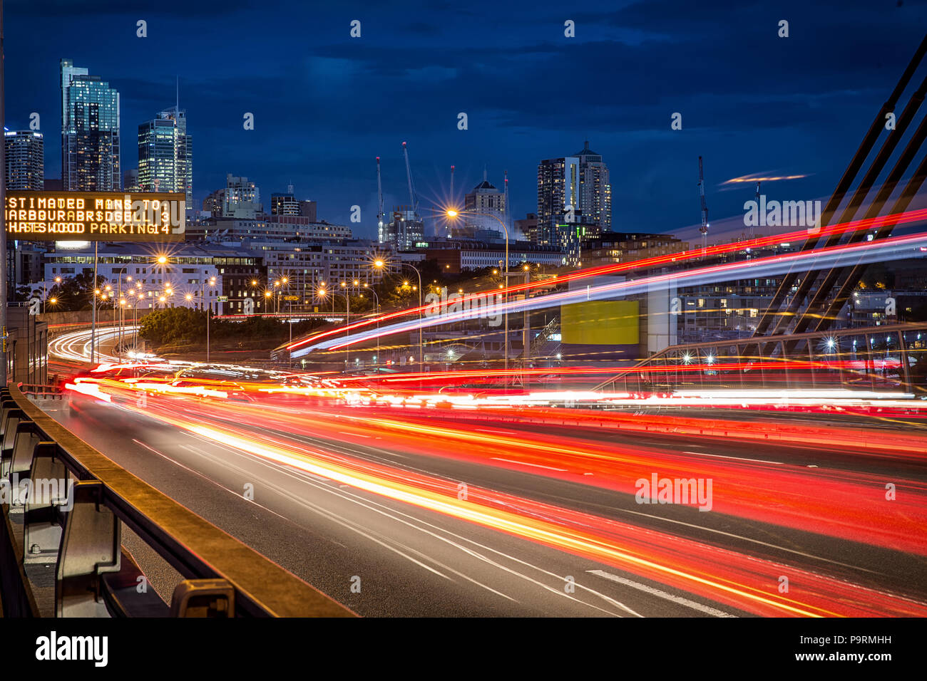 Sentieri di luce dai veicoli su ANZAC Bridge a Sydney Foto Stock