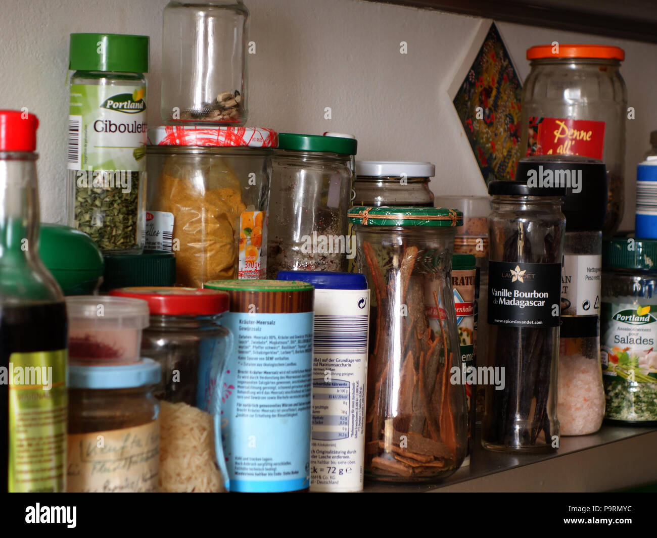 Vari vasi di spezie e condimenti su un tedesco di cuochi cucina ripiano spice Foto Stock