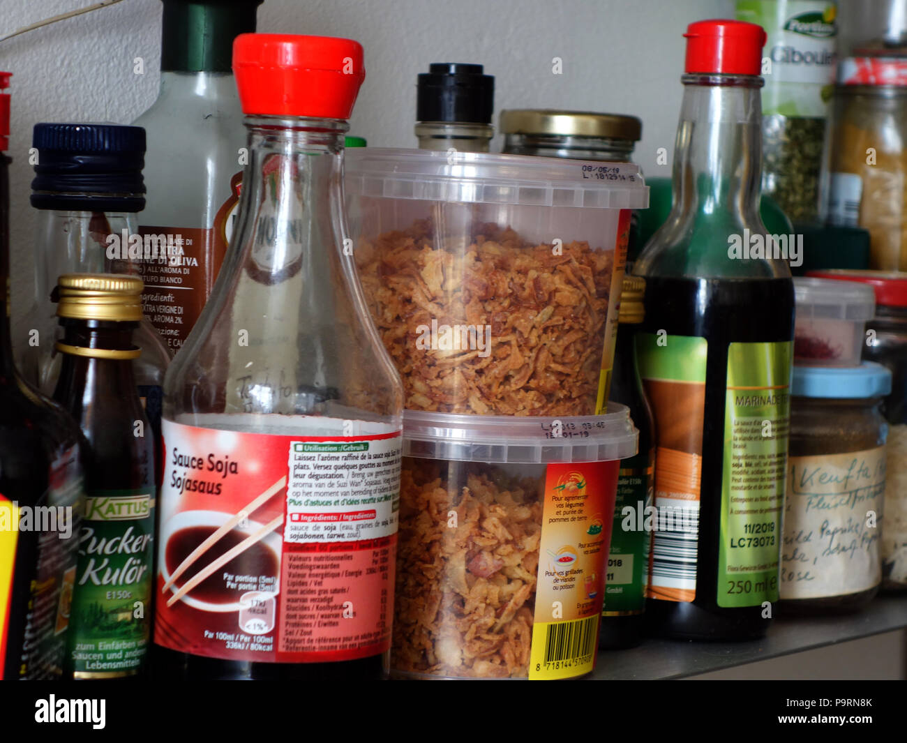 Vari vasi di spezie e condimenti su un tedesco di cuochi cucina ripiano spice Foto Stock