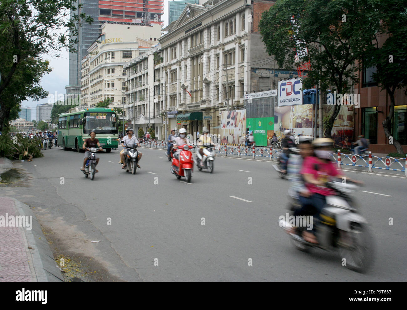 Moto, ciclomotori e autobus verde di guida su strada, Ho Chi Minh City, Vietnam Foto Stock
