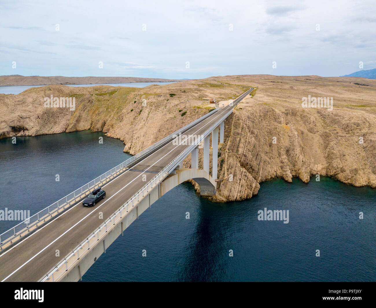 Vista aerea del ponte dell'isola di Pag, Croazia, su strada. Scogliera affacciato sul mare. Vetture attraversando il ponte visto da sopra Foto Stock