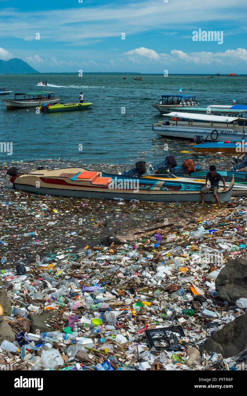 Inquinamento di plastica floating accanto alle piccole imbarcazioni presso il lungomare in Semporna città di Sabah, (Borneo malese, Malaysia. Foto Stock