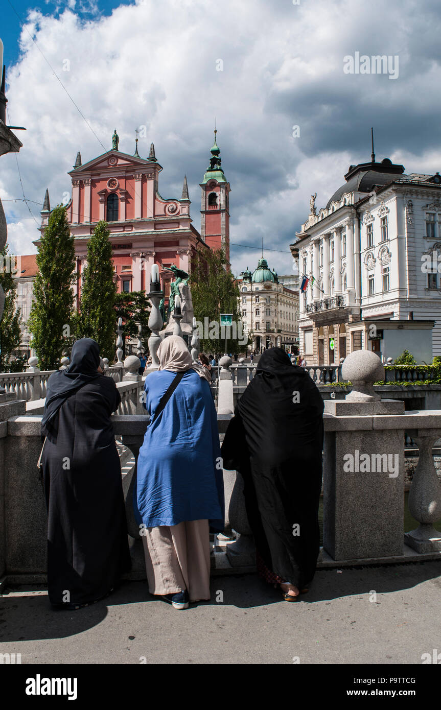 Lubiana, Slovenia: donne musulmane in Piazza Prešeren affacciato sul Tromostovje, ponte triplo, con la Chiesa dei Francescani dell'Annunciazione Foto Stock