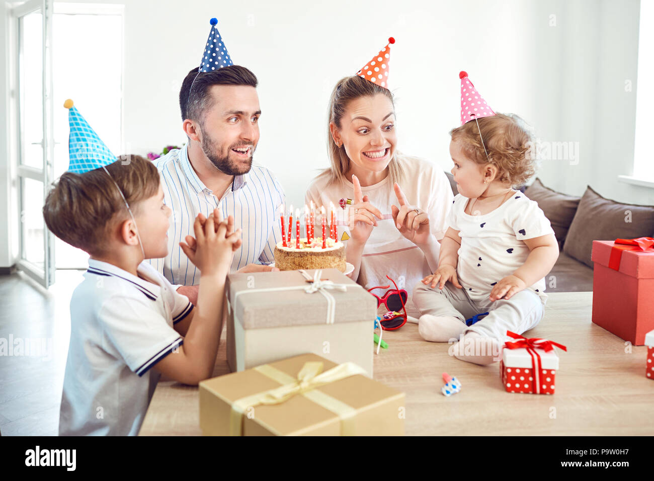 Una famiglia felice con torta celebra un compleanno. Foto Stock