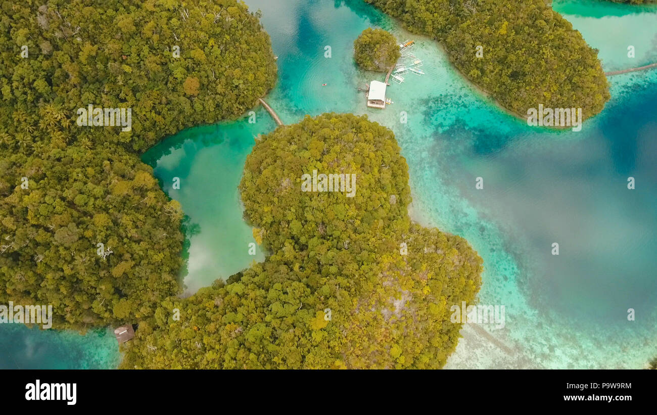 Vista aerea: spiaggia, isola tropicale, Baia Mare e laguna, Siargao. Paesaggio tropicale hill, nuvole e montagne rocce con la foresta pluviale. Acque azzurre della laguna. Paesaggio Shore Bay. Concetto di viaggio. Foto Stock