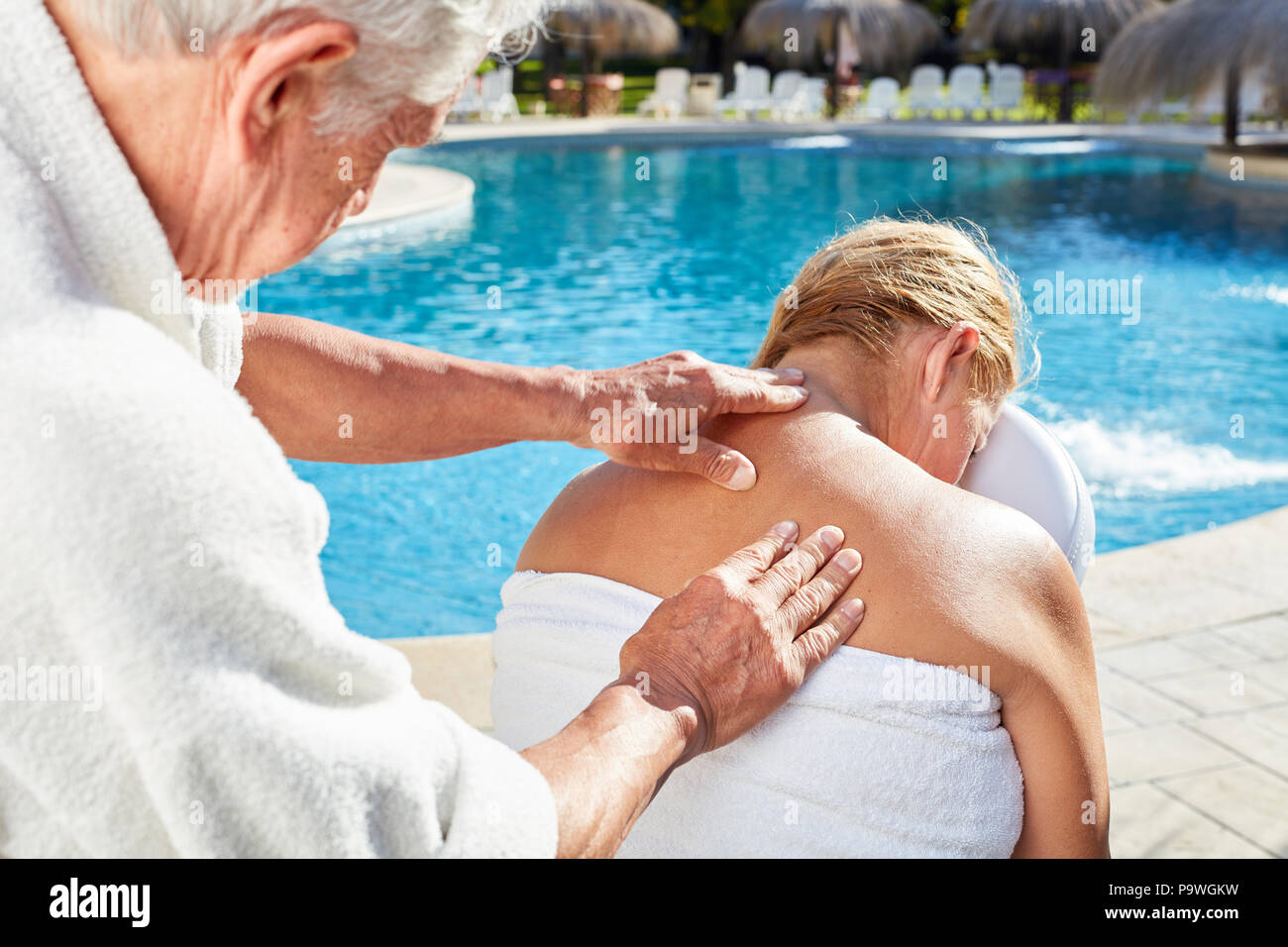 Uomo Donna dà un massaggio benessere per la schiena e la spalla in piscina Foto Stock
