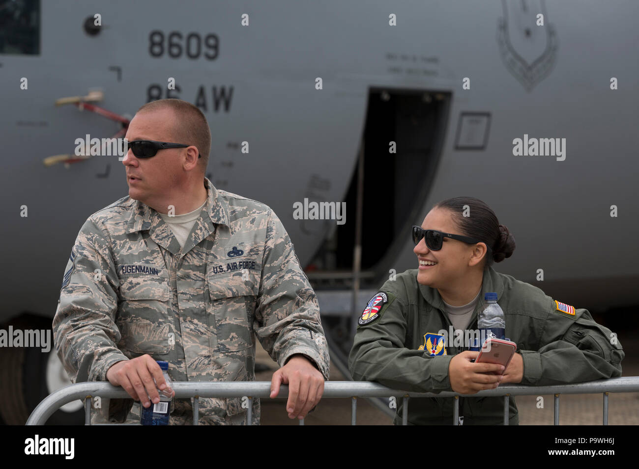 Un volontario e la donna con la US Air Force stare di fronte a loro C-130 aeromobile all'Airshow di Farnborough, il 18 luglio 2018, a Farnborough, Inghilterra. Foto Stock